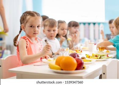 Group Of Kids Have Lunch In Daycare. Children Eat Healthy Food In Kindergarten