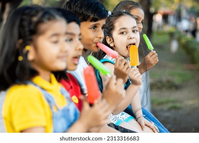 Group of kids having ice cream during summer camp .Kids having ice colorful ice candy enjoying summers - Powered by Shutterstock