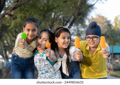 Group of kids having ice cream during summer camp .Kids having ice colorful ice candy enjoying summers - Powered by Shutterstock