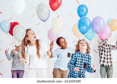 Group Of Kids Having A Party And Dancing With Balloons In Their Hands