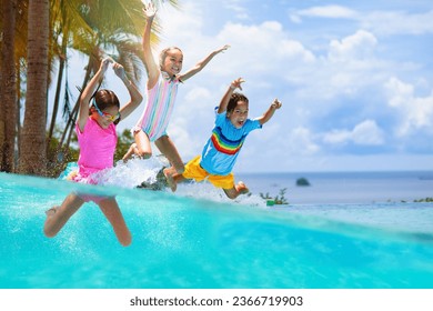 Group of kids jump into swimming pool. Summer water fun. Children play in outdoor pool. Summer family vacation with young kid. Holiday in tropical resort. Travel with child. - Powered by Shutterstock