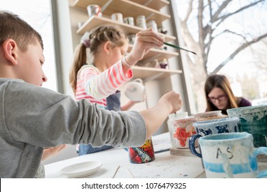 Group Of Kids Painting Pottery In A Class