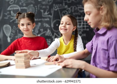 Group Of Kids Playing Jenga Wooden Bricks At School