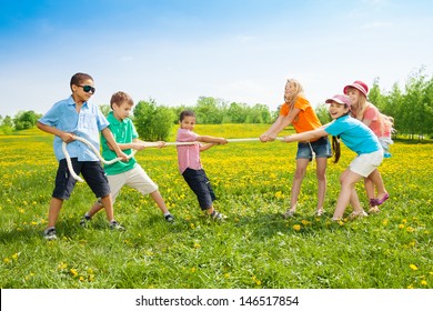 Group Of Kids Playing Pulling The Rope In The Dandelion Field