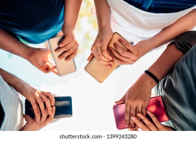 Group Of Kids Playing Video Games On Smart Phone After School