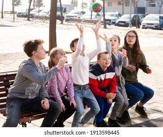 Group Of Kids Relaxing On Bench On Playground, Playing With Ball True Or False Game