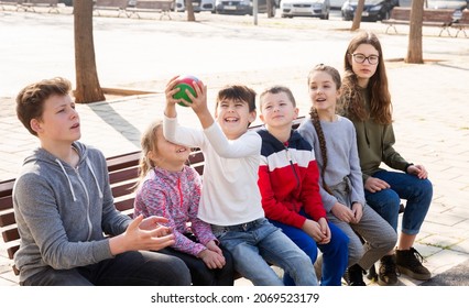 Group Of Kids Relaxing On Bench On Playground, Playing With Ball True Or False Game