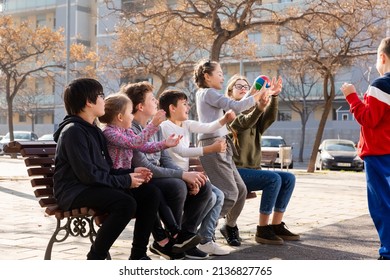 Group Of Kids Relaxing On Bench On Playground, Playing With Ball True Or False Game