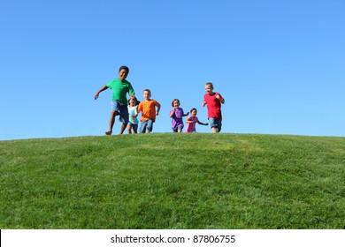 Group Of Kids Running On Grass Hill With Blue Sky