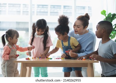 Group of kids and senior woman playing indoor, children with teacher in preschool, portrait of children and friends education concept - Powered by Shutterstock