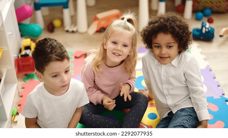 Group of kids sitting on floor smiling confident at kindergarten - Shutterstock ID 2292077935