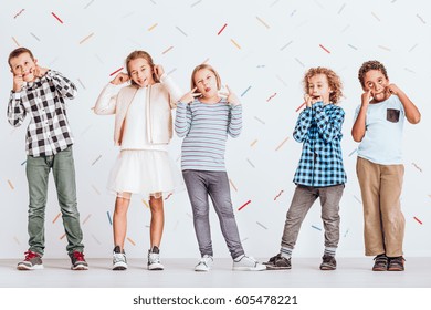 Group Of Kids Standing Next To Each Other And Pulling Faces