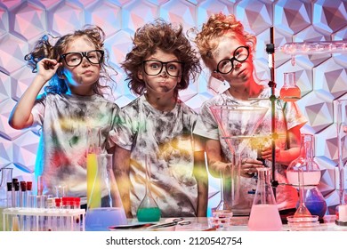 Group Of Kids In Stylish Glasses And Matted Hair Standing All Black After Conducting Experiments In A Chemical Laboratory. Science Experiments And Children. 