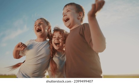 group of kids team hugging a jumping and rejoicing outdoors. happy family teamwork kid dream concept. family children sisters brothers have lifestyle fun hugging in the park in nature - Powered by Shutterstock