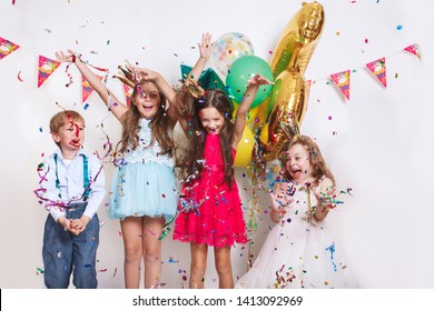 Group Of Kids Throwing Colorful Confetti And Looking Happy On Birthday Party