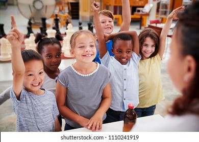 Group Of Kids Volunteering To Answer Teacher's Question