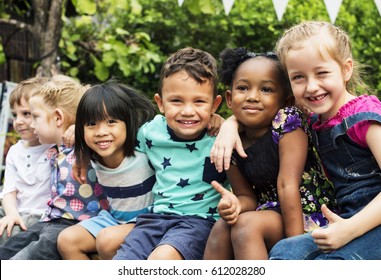 Group of kindergarten kids friends arm around sitting and smiling fun