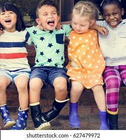 Group of kindergarten kids friends arm around sitting and smiling fun - Shutterstock ID 627479972