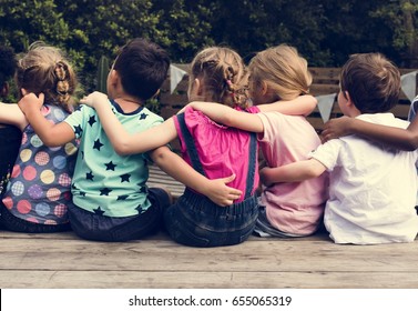 Group Of Kindergarten Kids Friends Arm Around Sitting Together