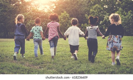 Group of kindergarten kids friends holding hands playing at park