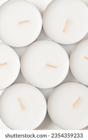 Group of large tealights, long-burning candles, from above. Also known as nightlights, tea lites, t-lites or t-candles in thin metal cups, so that the wax can liquefy completely while lit.