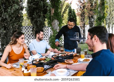 Group Of Latin Friends Eating Tacos In A Mexican Restaurant Or Bar Attended By Waiter In Mexico Latin America