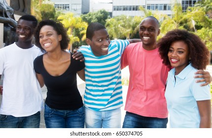 Group Of Laughing African American Man And Woman Walking In The City