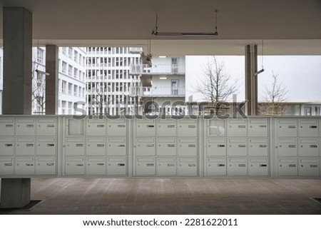 A group of letterboxes at the foot of an apartment building