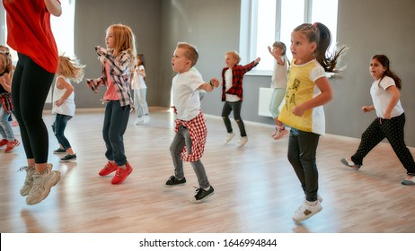 Group Of Little Boys And Girls Dancing While Having Choreography Class In The Dance Studio. Female Dance Teacher And Children. Contemp Dance. Hip Hop. Kids And Sport. Full Length