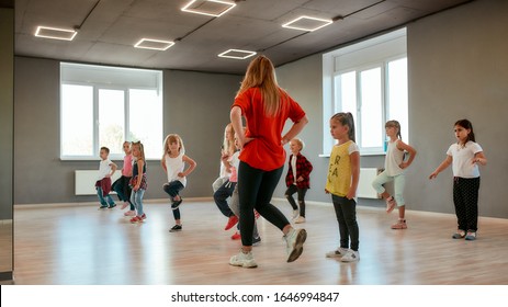 Group Of Little Boys And Girls Dancing While Having Choreography Class In The Dance Studio. Dance Teacher And Children. Contemp Dance. Hip Hop. Kids And Sport. Full Length