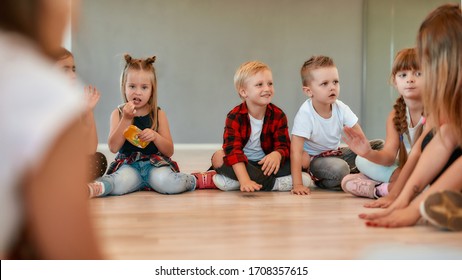 A Group Of Little Cute Girls And Boys Talking To Each Other While Sitting In Circle During Choreography Class In The Dance Studio. Friendship. Taking A Break. Dance School