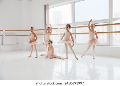 Group of little girls in ballet attire performing various dance movements at modern dance studio. Classical ballet school. Concept of art, sport, education, hobby, active lifestyle, leisure time. - Powered by Shutterstock