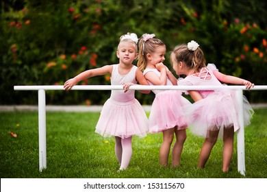 Group of little girls doing ballet bar exercises at beautiful summer garden background - Powered by Shutterstock