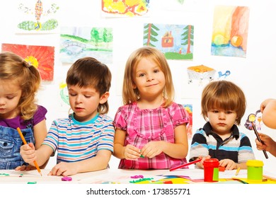 Group of little kids on painting class sitting together with pencils and paints - Shutterstock ID 173855771
