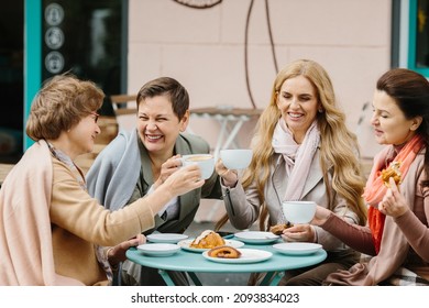 Group Of Lovely Middle Age Senior Mature Women Girlfriends Meeting For Coffee And Tea With Cakes At Coffee Shop Sharing Time Together Enjoying Converstion Happy And Cheerful Gossiping