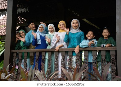 group of malay with colorful traditional clothing standing side by side waving - Shutterstock ID 1688652952