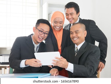 Group Of Malaysian Businesspeople Meeting Or Having Discussion On Desk Inside Office Room.