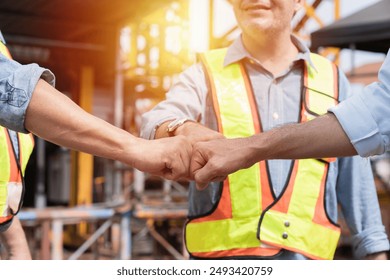 Group of male engineer construction putting their hands together at construction site. Group of male construction builder working at construction site. Unity and teamwork concept - Powered by Shutterstock