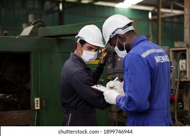 Group Of Male Engineer Worker Wearing Face Mask Working At Factory. Team Of Male Technician Worker Checking, Repair Or Maintenance Machine In The Industry Factory. Industry And Health Care Concept