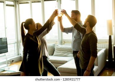 Group of male and female friends having fun at home and toasting with cider bottles - Shutterstock ID 1285921777