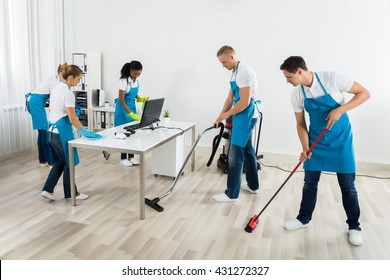 Gruppe männlicher und weiblicher Janitoren in einheitlicher Reinigung des Amtes
