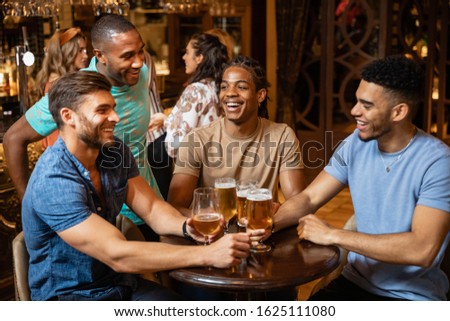 A group of male friends having a beer together at a bar.