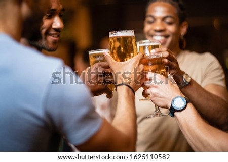 A group of male friends having a celebratory toast togetherat a bar.