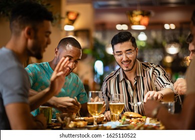 A group of male friends having a meal together at a restaurant in Newcastle-Upon-Tyne.