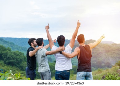 Group of male hiking and camping. Back view of group of young tourists man camping standing hugging on shoulder together and raising up his hands on mountain 