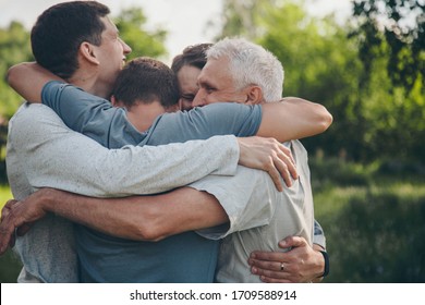A Group Of Male Hugging. Portrait Of Happy People. Joy After A Long Separation. The Concept Of Relationships In The Family, Friends