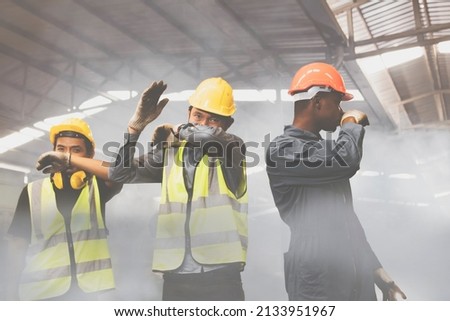 Group of male industrial workers are fleeing and covering their noses with toxic fumes, ammonia NH3 , and toxic chemicals from the explosions, causing severe breathing difficulties