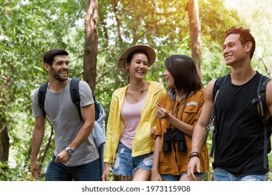 Group of male and woman backpackers hikers hiking with backpacks walking on road along forest trial. Camping, jungle adventure concept 