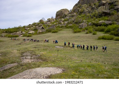 Group of many people hiking on a mountain trail
