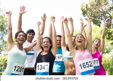 Group of marathon runners cheering after winning a race in the park - Powered by Shutterstock